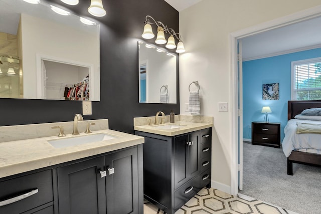 ensuite bathroom with a sink, baseboards, two vanities, and ornamental molding