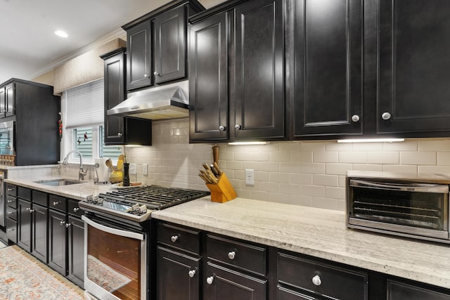 kitchen featuring sink, backsplash, crown molding, light tile patterned floors, and stainless steel range with gas stovetop