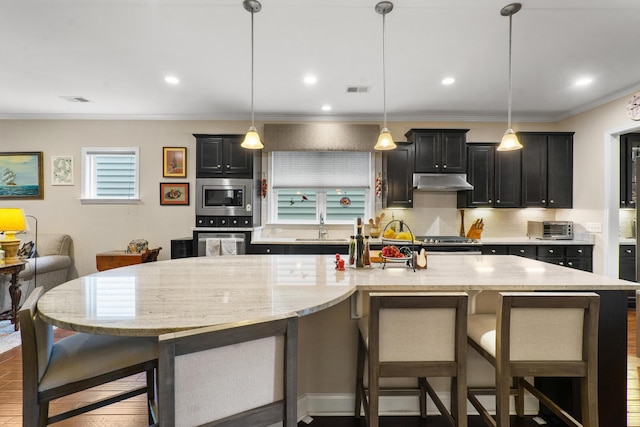 kitchen with pendant lighting, a spacious island, stainless steel appliances, and a breakfast bar area