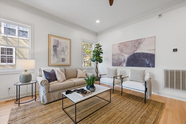 living room with crown molding and light hardwood / wood-style floors