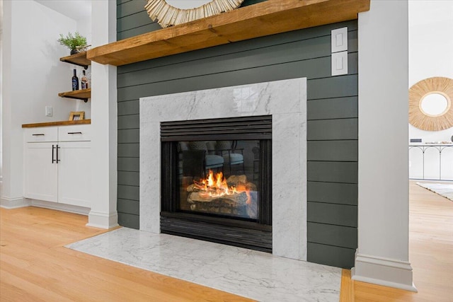 room details featuring hardwood / wood-style flooring and a high end fireplace