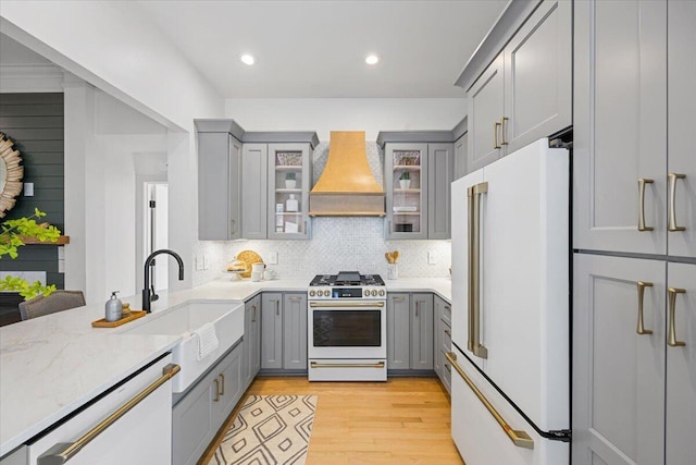 kitchen featuring sink, light hardwood / wood-style flooring, gray cabinetry, high quality appliances, and custom exhaust hood