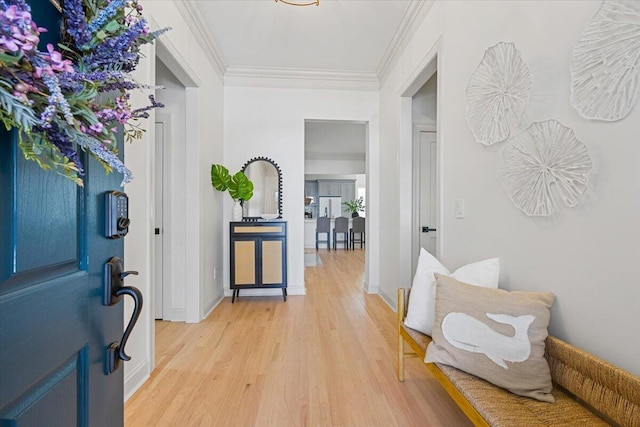 entrance foyer featuring crown molding and light wood-type flooring