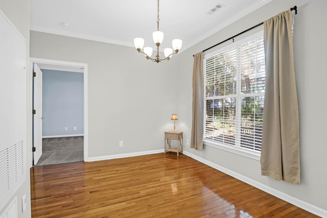 unfurnished room with a notable chandelier, ornamental molding, and hardwood / wood-style flooring