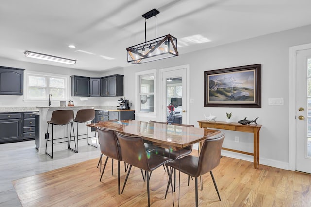 dining space with light wood-style flooring and baseboards