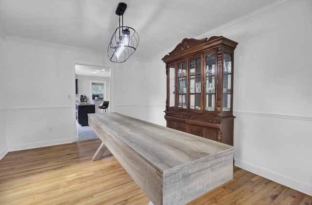 dining room with ornamental molding, wood finished floors, and baseboards