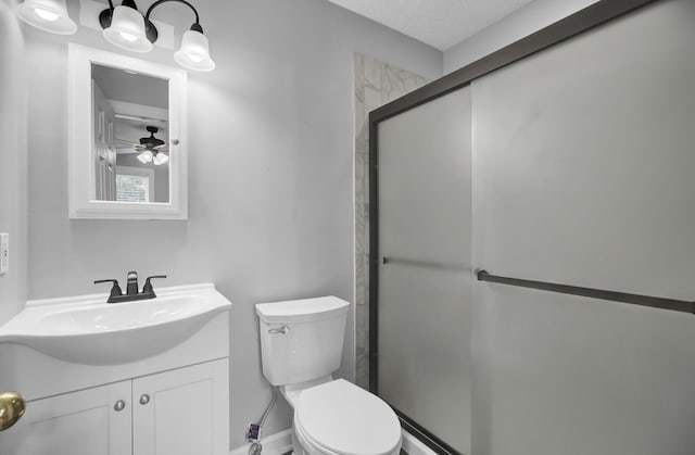 bathroom featuring vanity, toilet, and an enclosed shower