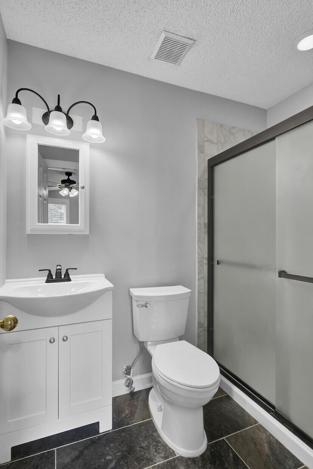 bathroom with a textured ceiling, toilet, vanity, visible vents, and a shower stall