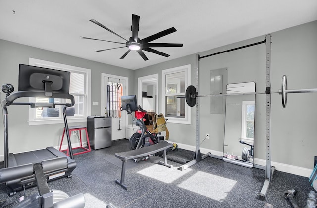 exercise area featuring ceiling fan and baseboards