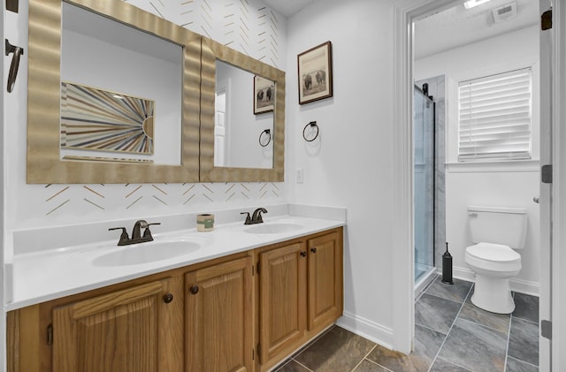 full bath featuring toilet, double vanity, a sink, and visible vents