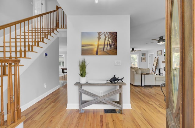 hall featuring stairway, baseboards, and wood finished floors