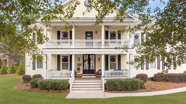 view of front of home with a front lawn, a balcony, and covered porch