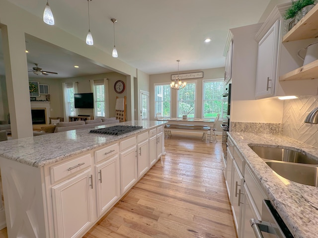 1129 Plantation Overlook Dr, Moncks Corner, SC 29461 - kitchen featuring a chandelier, appliances with stainless steel finishes, light wood-style floors, open shelves, and a fireplace