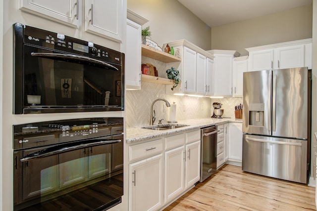1129 Plantation Overlook Dr, Moncks Corner, SC 29461 - kitchen with stainless steel appliances, white cabinetry, open shelves, backsplash, and light stone counters