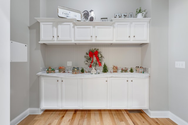 bar featuring white cabinetry and light wood-type flooring