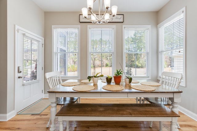 dining space featuring light hardwood / wood-style flooring and a notable chandelier