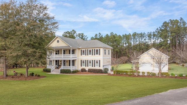 view of front of property featuring a porch, a garage, and a front lawn