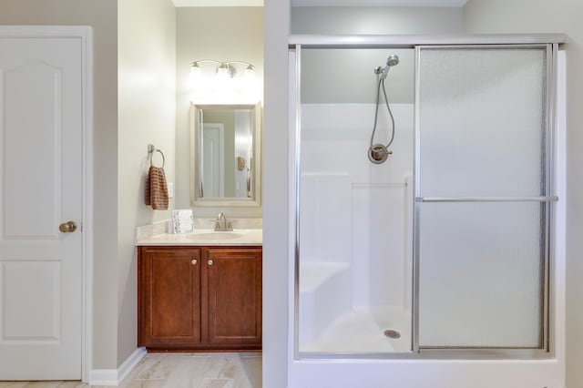 bathroom featuring a shower with door and vanity