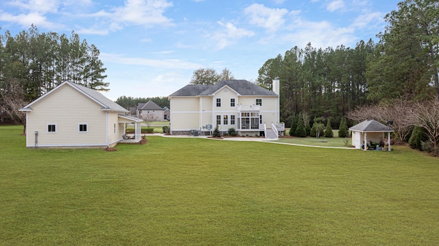 rear view of property featuring a porch, an outdoor structure, and a lawn