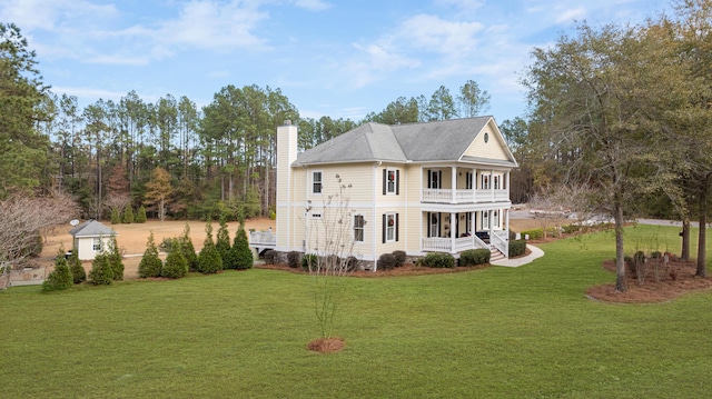 rear view of house featuring a yard and a balcony