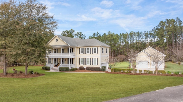 view of front of house featuring a porch, a balcony, a front yard, and a garage