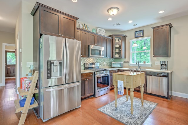 100 Canal Rd, Saint George, SC 29477 - kitchen with appliances with stainless steel finishes, light countertops, dark brown cabinetry, backsplash, and pendant lighting