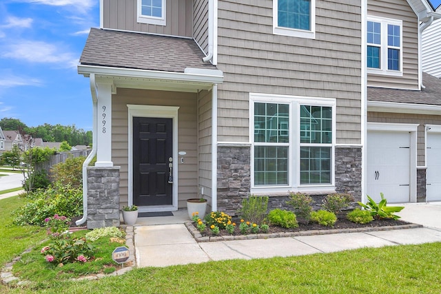 9998 Winged Elm St, Ladson, SC 29456 - property entrance with stone siding, board and batten siding, a shingled roof, and an attached garage