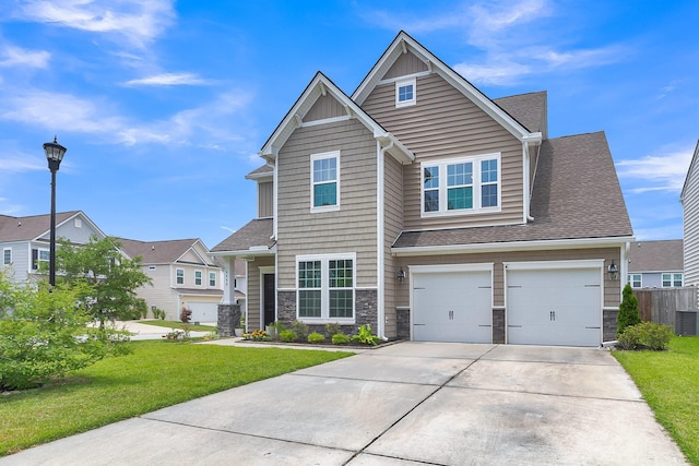 9998 Winged Elm St, Ladson, SC 29456 - view of front facade with stone siding, driveway, an attached garage, and roof with shingles