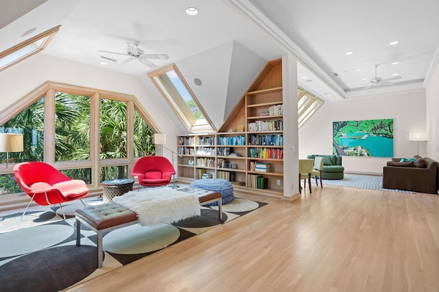 living area featuring ceiling fan, vaulted ceiling, crown molding, and light hardwood / wood-style flooring