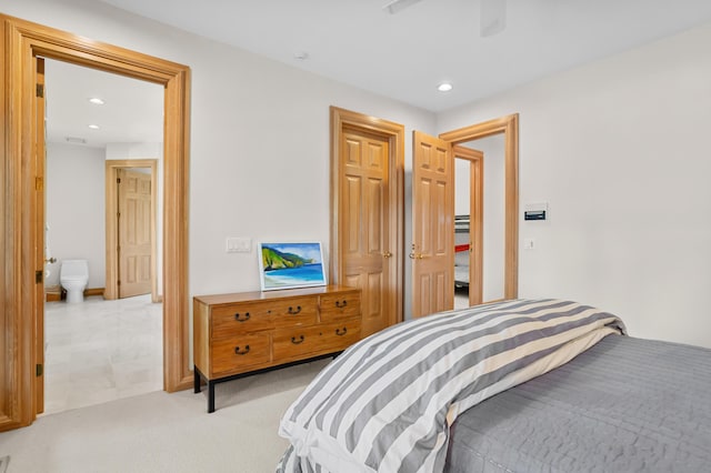 carpeted bedroom with ceiling fan and ensuite bath