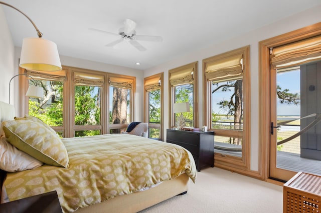 bedroom featuring ceiling fan, light colored carpet, multiple windows, and access to outside