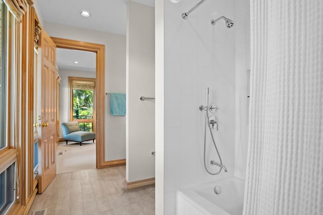 bathroom featuring tiled shower / bath combo and hardwood / wood-style flooring