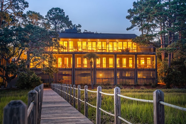 back house at dusk featuring a balcony