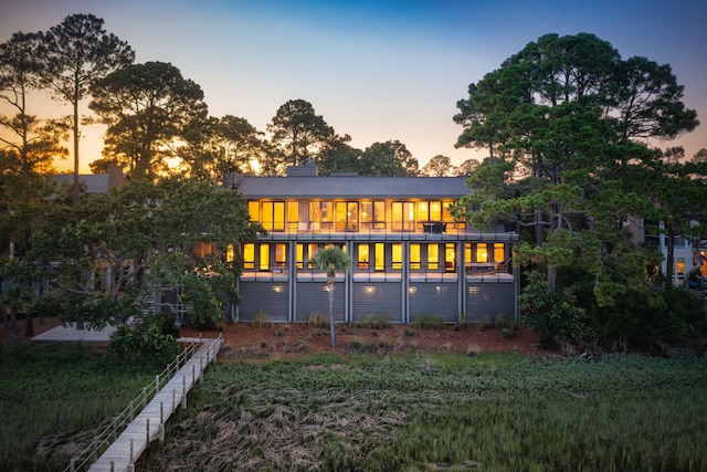 back house at dusk with a sunroom