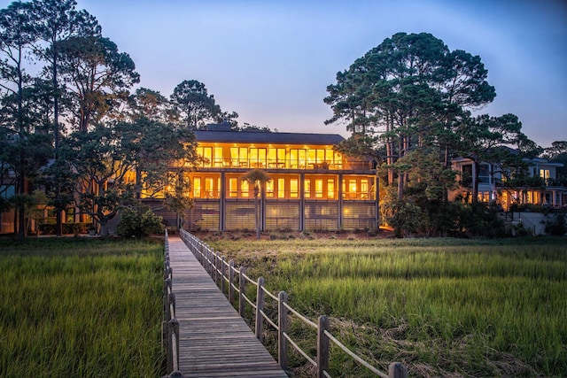 back house at dusk with a balcony