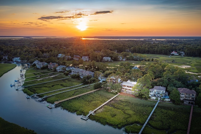 aerial view at dusk featuring a water view