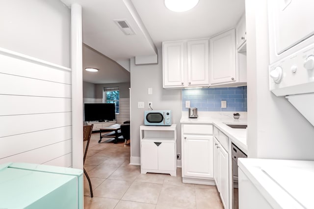 kitchen with light tile patterned floors, white cabinets, dishwasher, and white microwave