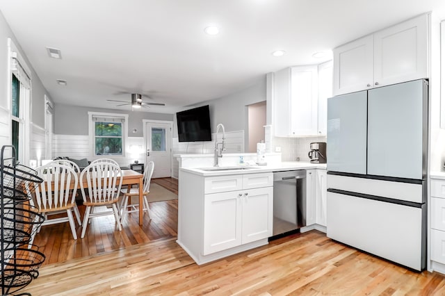 kitchen with white cabinetry, a sink, dishwasher, a peninsula, and white refrigerator