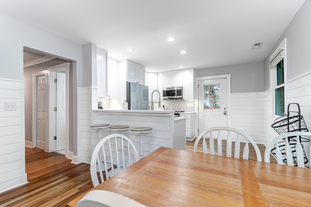 dining space featuring wainscoting, light wood-type flooring, and recessed lighting