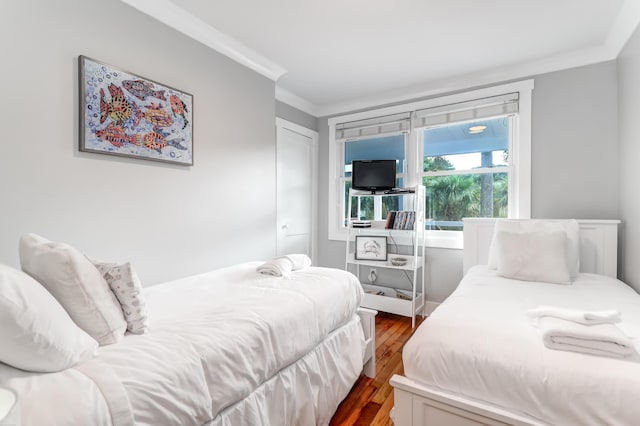 bedroom featuring ornamental molding and dark wood-type flooring