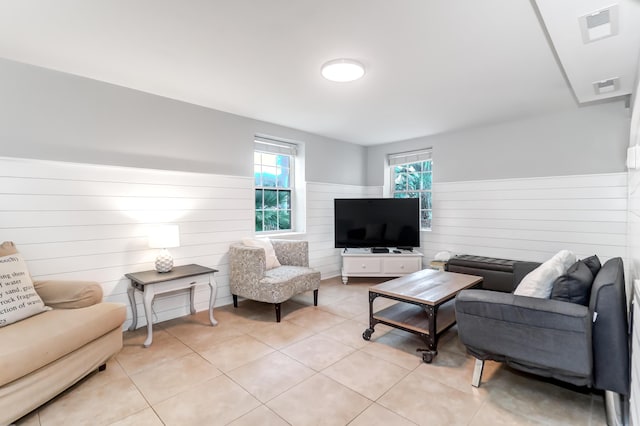 living room with wainscoting, visible vents, and light tile patterned flooring