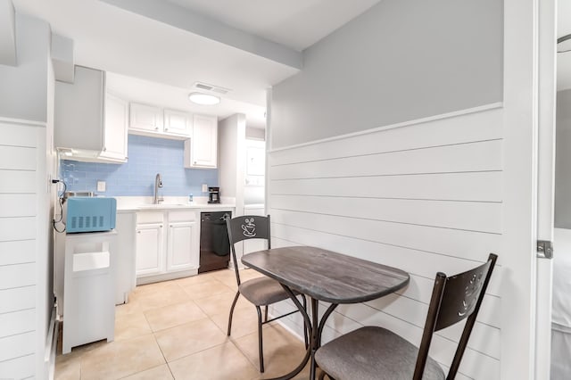 kitchen with light tile patterned floors, black dishwasher, visible vents, light countertops, and a sink