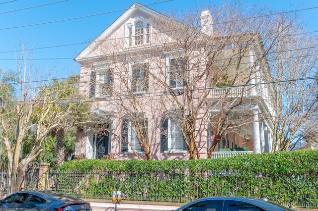 view of front facade featuring a fenced front yard and a chimney
