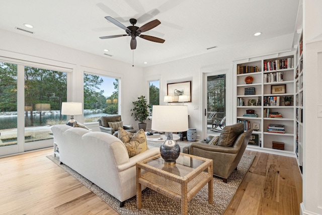 living area with a ceiling fan, recessed lighting, visible vents, and light wood-style floors