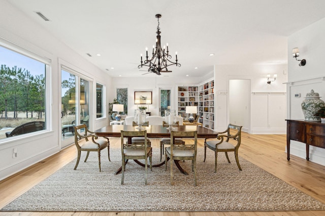 dining area with light wood-type flooring, visible vents, an inviting chandelier, and recessed lighting