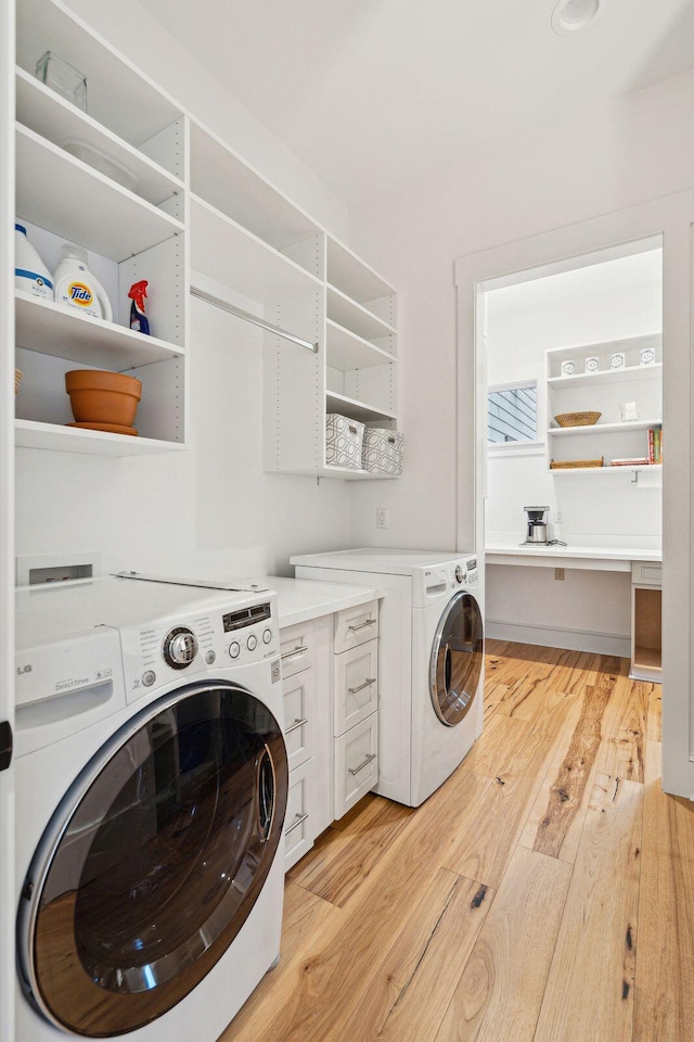 washroom with cabinet space, light wood-style flooring, and independent washer and dryer