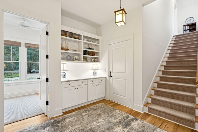 interior space featuring light wood-style floors, ceiling fan, and baseboards