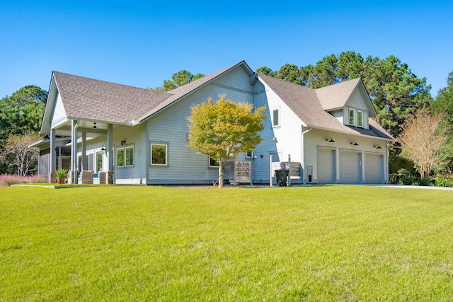 exterior space featuring an attached garage, a front lawn, and roof with shingles