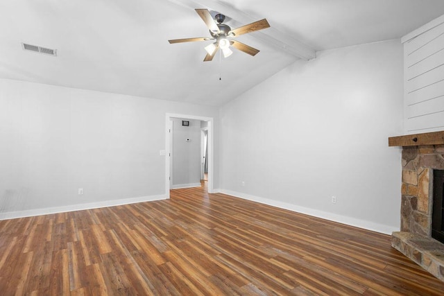 unfurnished living room with a stone fireplace, dark wood-type flooring, vaulted ceiling with beams, and ceiling fan