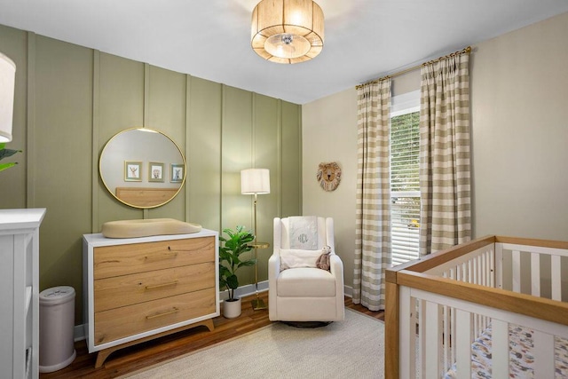 bedroom with a crib and hardwood / wood-style floors